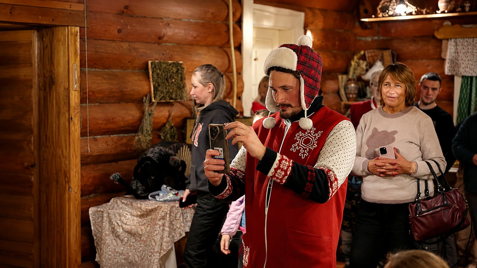 Помощник Деда Мороза фотографирует гостей внутри Дачи Бабы Яги.