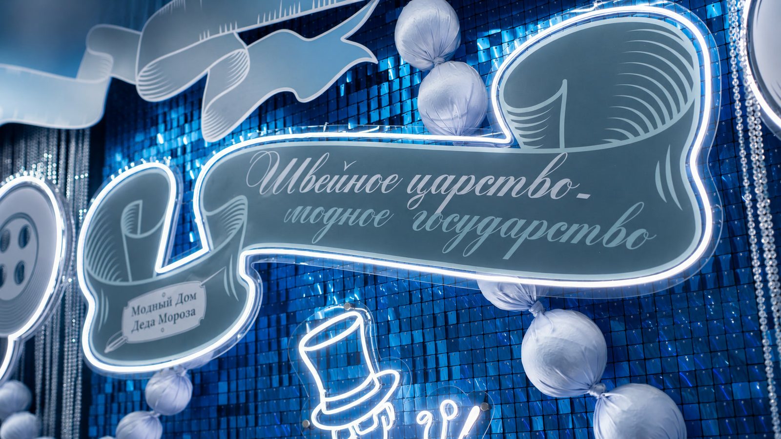 Светящаяся вывеска «Швейное царство — модное государство» с подписью «Модный Дом Деда Мороза».